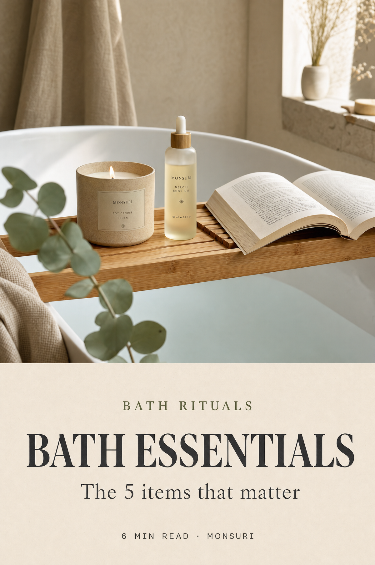 Bath essentials cover — bamboo bath tray bridging a tub holding a soy candle, body oil, and an open book; magazine cover composition for Monsuri Journal