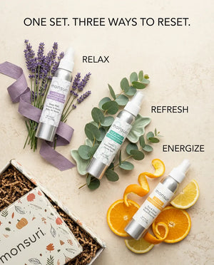 Monsuri lavender, eucalyptus, and citrus shower sprays styled with lavender sprigs, eucalyptus leaves, and orange slices, labeled relax, refresh, energize.