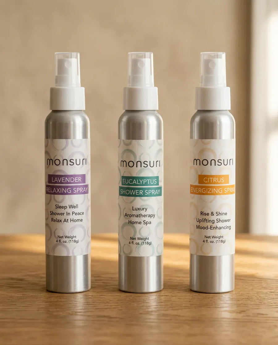 The three Monsuri aromatherapy shower sprays side by side - LAVENDER relaxing spray, EUCALYPTUS shower spray and CITRUS energizing spray, 4 fl oz each, on a warm neutral background