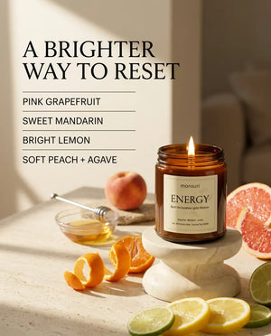 Infographic listing the Monsuri ENERGY candle's scent notes — pink grapefruit, sweet mandarin, bright lemon, soft peach and agave — around the lit jar with citrus.