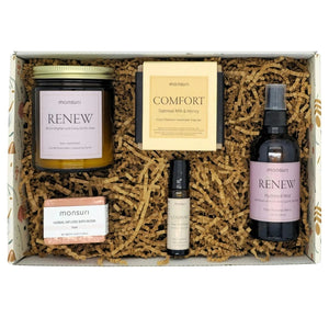 Rose sandalwood candle from sympathy gift basket burning softly next to comfort soap and healing mist for gentle bereavement support