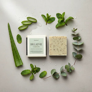 Natural eucalyptus peppermint soap with fresh botanical leaves showing organic ingredients for aromatherapy shower and respiratory clarity benefits