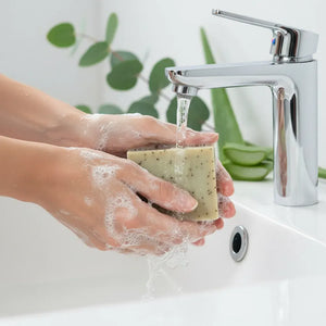 Woman washing hands with Monsuri eucalyptus aloe natural soap bar showing gentle lather and peppermint leaf texture for refreshing shower experience
