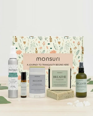 All five pieces of the Monsuri Get Well Soon set - the 4 oz eucalyptus shower spray, the 4.5 oz eucalyptus aloe soap bar, the 2 oz RECOVER muscle-reset body oil, the 2.3 oz cooling muscle balm stick and the BREATHE clarity essential oil roller