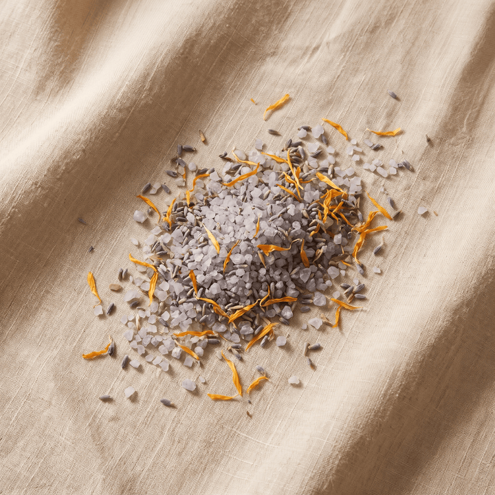 Mediterranean Dead Sea bath salt with dried lavender and calendula petals on linen
