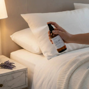 Woman spraying lavender sleep spray on pillow in peaceful bedroom setting