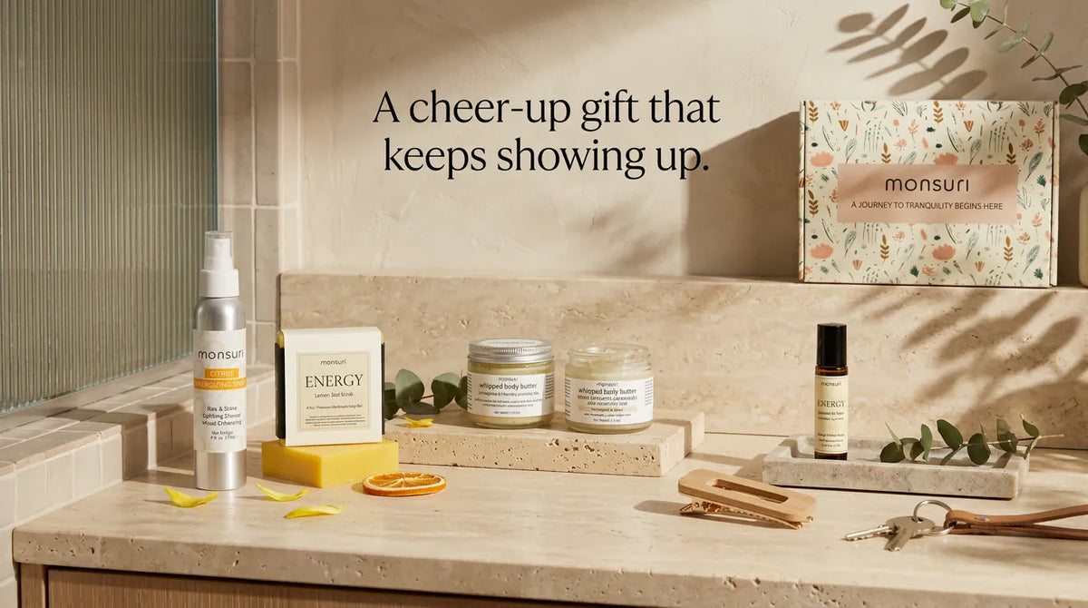 A cheer-up gift that keeps showing up - the five Little Box of Sunshine pieces along a travertine bathroom ledge with the botanical gift box