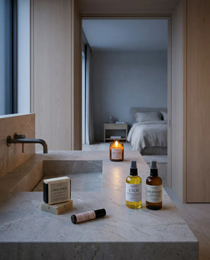 The five pieces set out along a stone counter with the bedroom beyond, the palo santo candle already lit