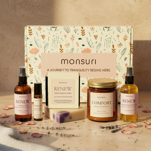 Thinking of you gift set with vanilla amber candle, raspberry vanilla soap, botanical body oil, hydrosol mist and essential oil roller arranged on marble surface