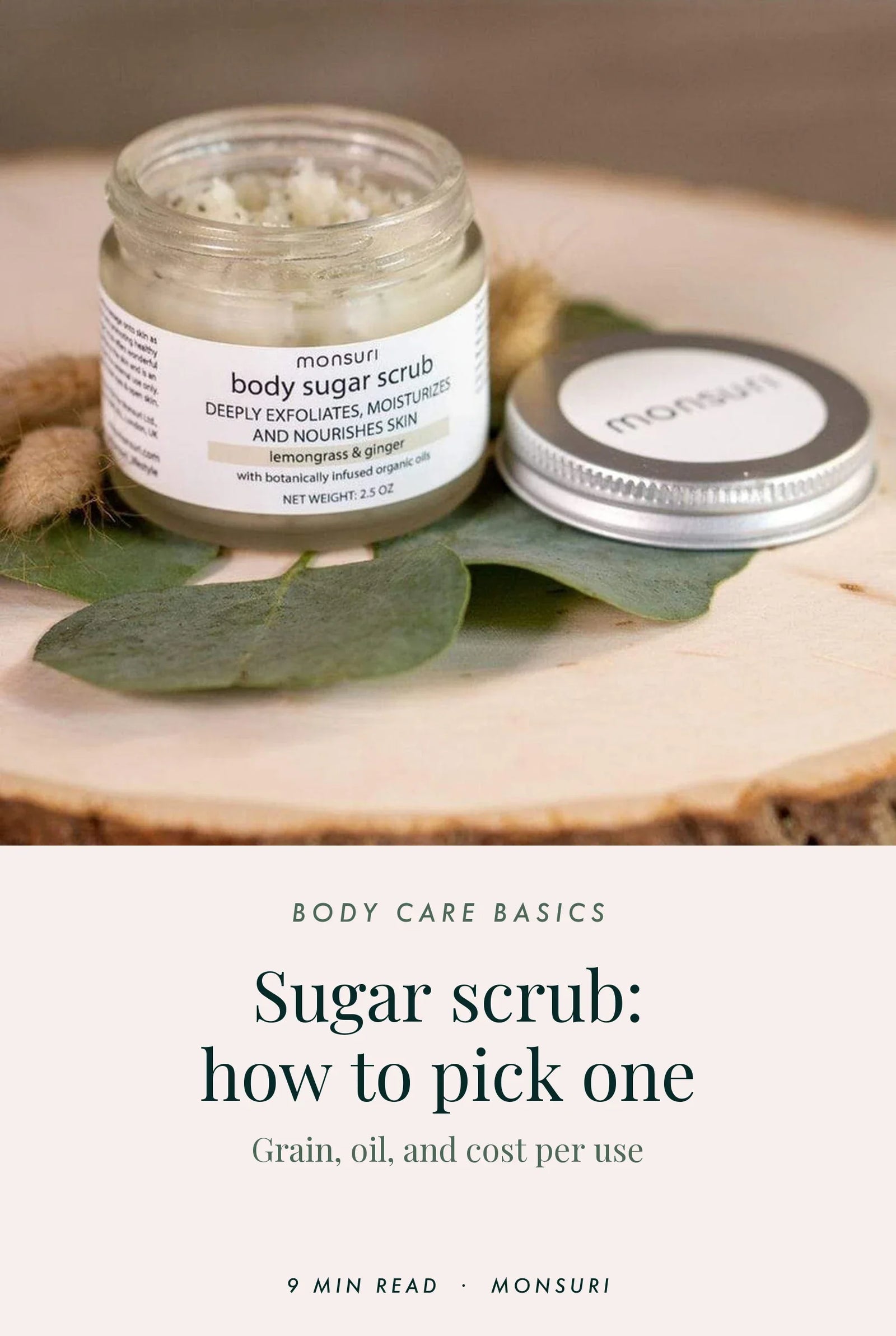 Sugar scrub buying guide cover — an open jar of Monsuri Lemongrass and Ginger body sugar scrub on a wood slice with eucalyptus, the pale sugar flecked with dark poppy seeds, above the title Sugar scrub: how to pick one, grain, oil, and cost per use.