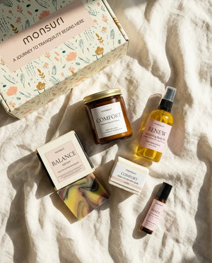 Overhead flat lay of all five Birthday Bliss pieces on rumpled linen beside the Monsuri botanical gift box
