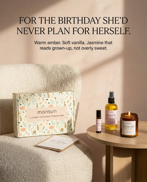 For the birthday she would never plan for herself - warm amber, soft vanilla and jasmine that reads grown-up rather than sweet, the gift box propped on a boucle chair beside the candle, body oil and roller