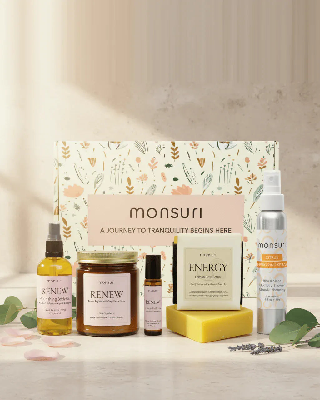 Bridesmaid Bliss gift set photographed in front of the Monsuri botanical kraft box - RENEW nourishing body oil 3.3 fl oz, rose and sandalwood candle 7 oz with 45 hour burn, essential oil roller 0.33 fl oz, ENERGY lemon zest scrub soap 4.5 oz and CITRUS energizing shower spray 4 fl oz in brushed aluminium