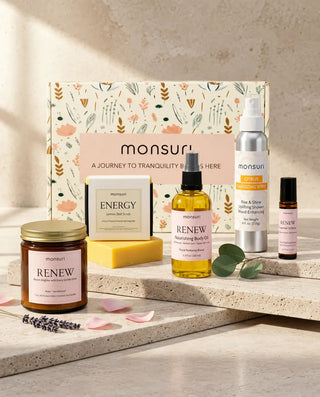 All five bridesmaid gifts in front of the botanical kraft box - RENEW rose and sandalwood candle 7 oz, CITRUS energizing shower spray 4 fl oz in brushed aluminium, ENERGY lemon zest scrub soap 4.5 oz, nourishing body oil 3.3 fl oz and essential oil roller 0.33 fl oz