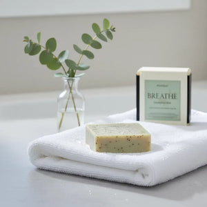 Monsuri Breathe eucalyptus soap bar with packaging on white towel showing premium handmade natural soap for spa gifts and self-care routine
