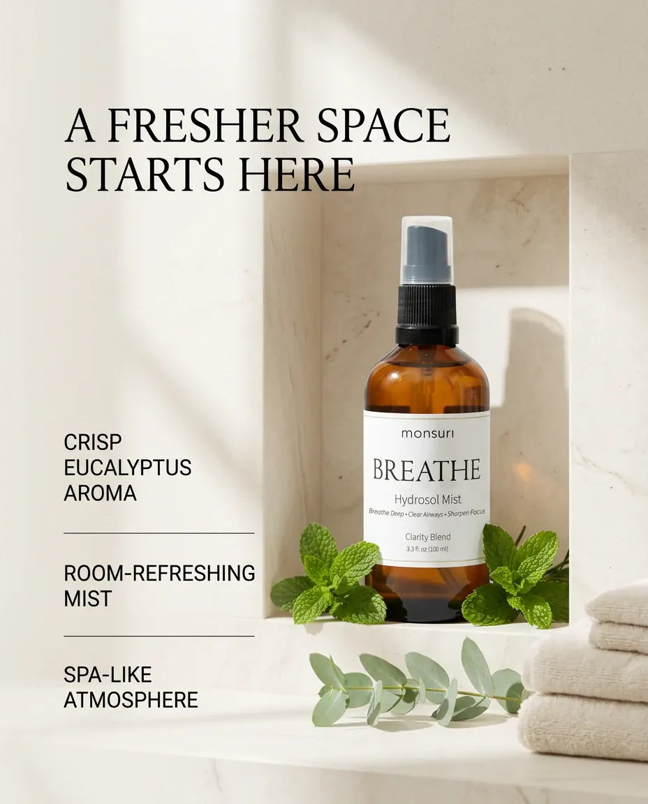 Monsuri BREATHE eucalyptus hydrosol in a stone alcove with folded towels and eucalyptus sprigs, captioned a fresher space starts here: crisp eucalyptus aroma, room-refreshing mist, spa-like atmosphere.