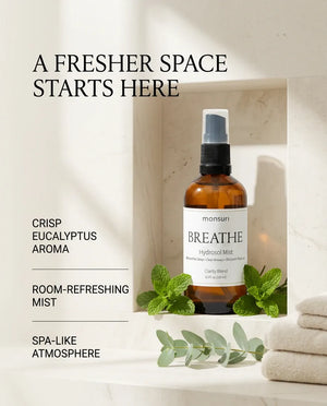 Monsuri BREATHE eucalyptus hydrosol in a stone alcove with folded towels and eucalyptus sprigs, captioned a fresher space starts here: crisp eucalyptus aroma, room-refreshing mist, spa-like atmosphere.
