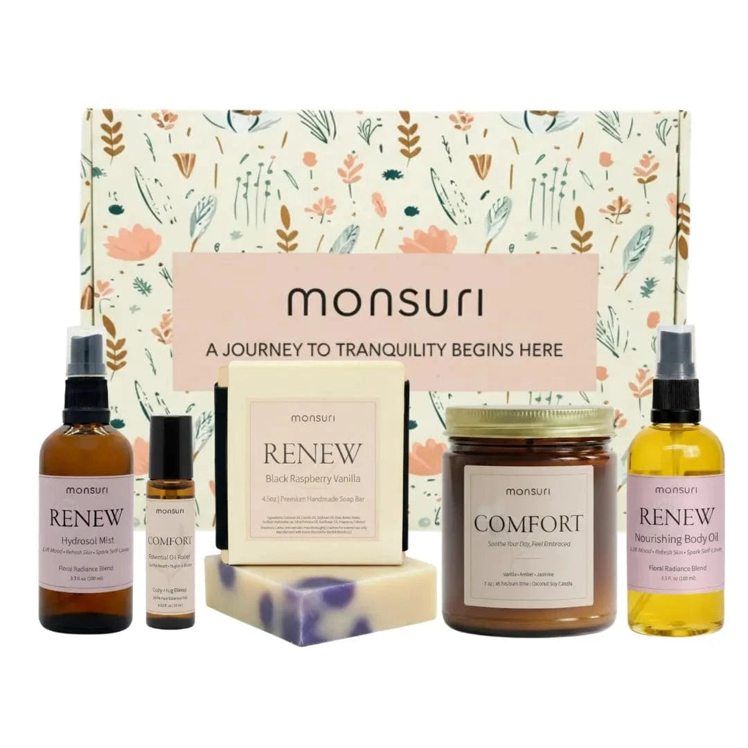 Thinking of you gift set with vanilla amber candle, raspberry vanilla soap, botanical body oil, hydrosol mist and essential oil roller arranged on marble surface