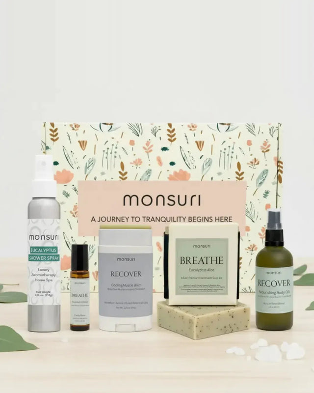 All five pieces of the Monsuri Get Well Soon set - the 4 oz eucalyptus shower spray, the 4.5 oz eucalyptus aloe soap bar, the 2 oz RECOVER muscle-reset body oil, the 2.3 oz cooling muscle balm stick and the BREATHE clarity essential oil roller