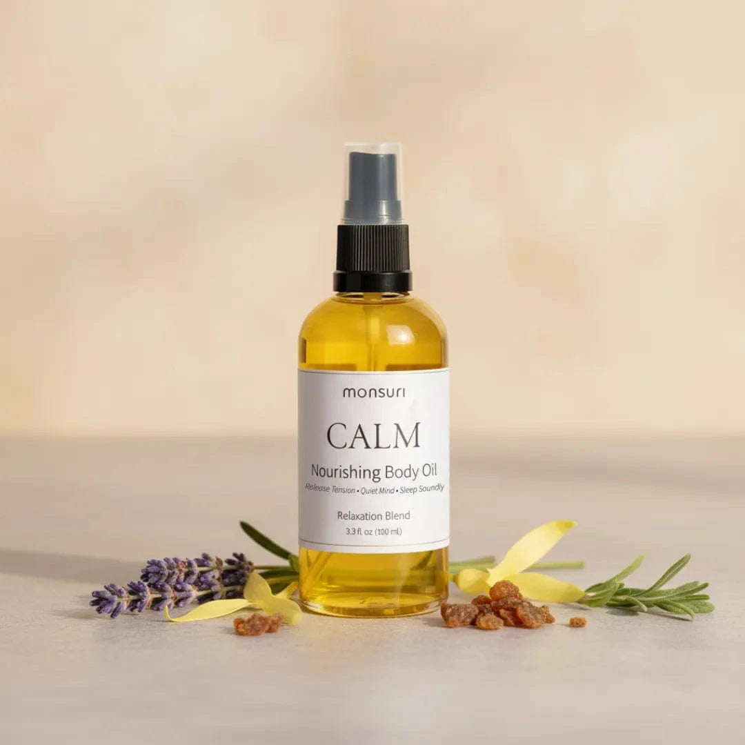 Self-care Sunday body oil — the Monsuri Lavender Body Oil in frosted-amber glass with matte black pump-spray top, the 60-second post-bath seal applied within the first minute of stepping out of the soak