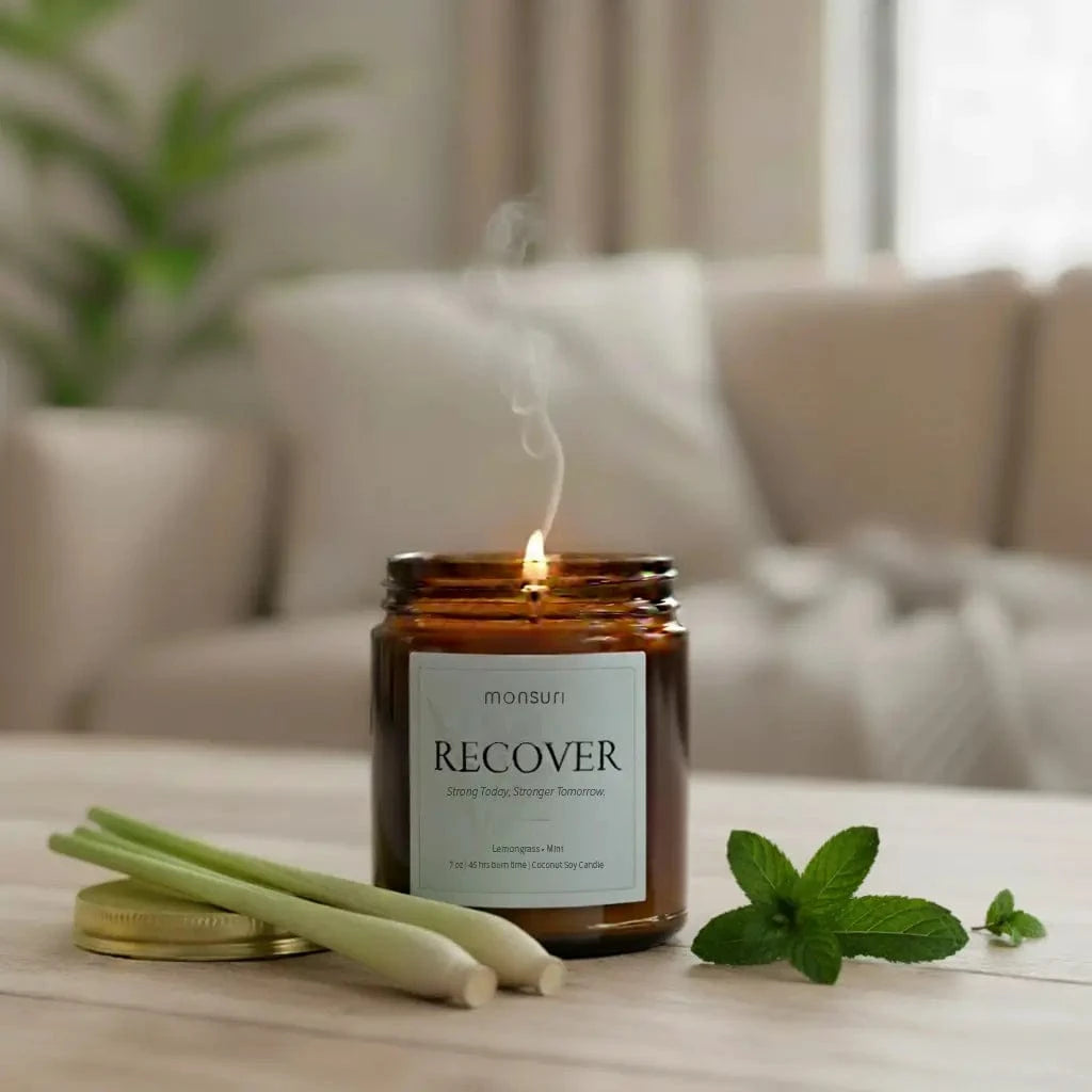Lemongrass mint recovery candle in amber glass burning with natural energizing aromatherapy