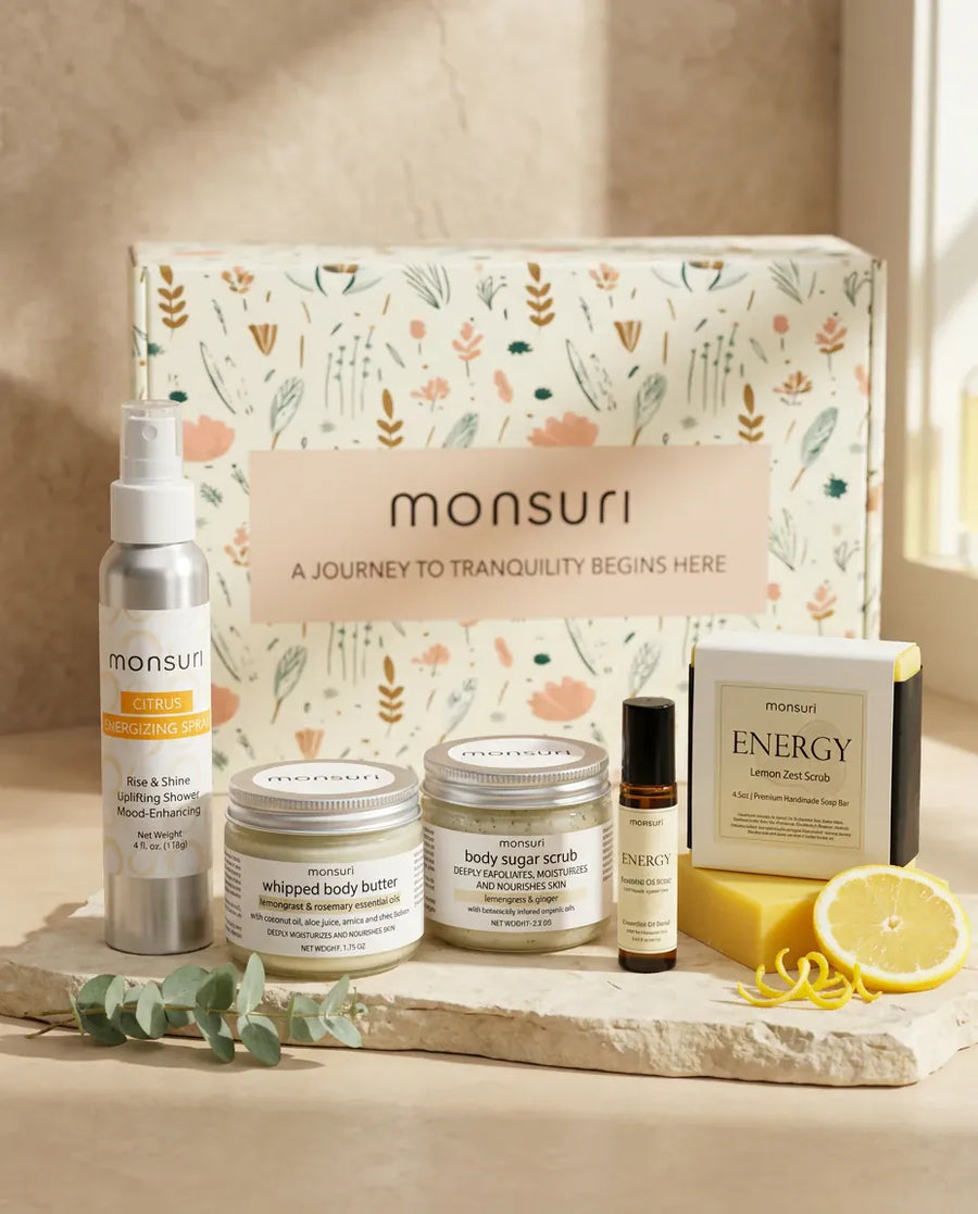 All five pieces of the Little Box of Sunshine cheer-up gift in front of the Monsuri botanical gift box - the 4 oz CITRUS energizing shower spray, the 1.75 oz lemongrass rosemary whipped body butter, the 2.5 oz lemongrass ginger body sugar scrub, the ENERGY essential oil roller and the 4.5 oz ENERGY lemon zest soap bar