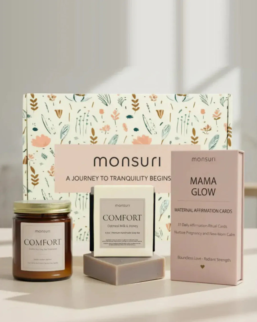 Mama Glow pregnancy and postpartum care set in front of the Monsuri botanical gift box - the COMFORT vanilla, amber and jasmine candle, the COMFORT oatmeal milk and honey soap bar, and the MAMA GLOW deck of 31 maternal affirmation-ritual cards