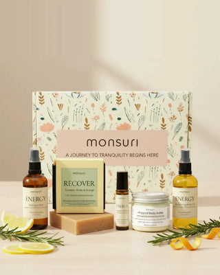 Energizing gifts for mom: the five-piece Monsuri set with citrus hydrosol mist, turmeric honey and orange soap, energy roller, whipped body butter and nourishing body oil in front of the botanical kraft gift box