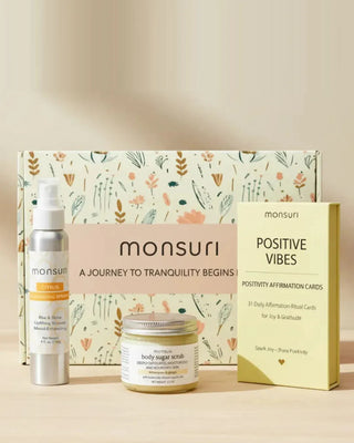 Positivity Boost gift set in front of the Monsuri botanical gift box - 4 fl oz citrus energizing shower spray in brushed aluminium, 2.5 oz lemongrass and ginger body sugar scrub and the POSITIVE VIBES deck of 31 daily affirmation-ritual cards