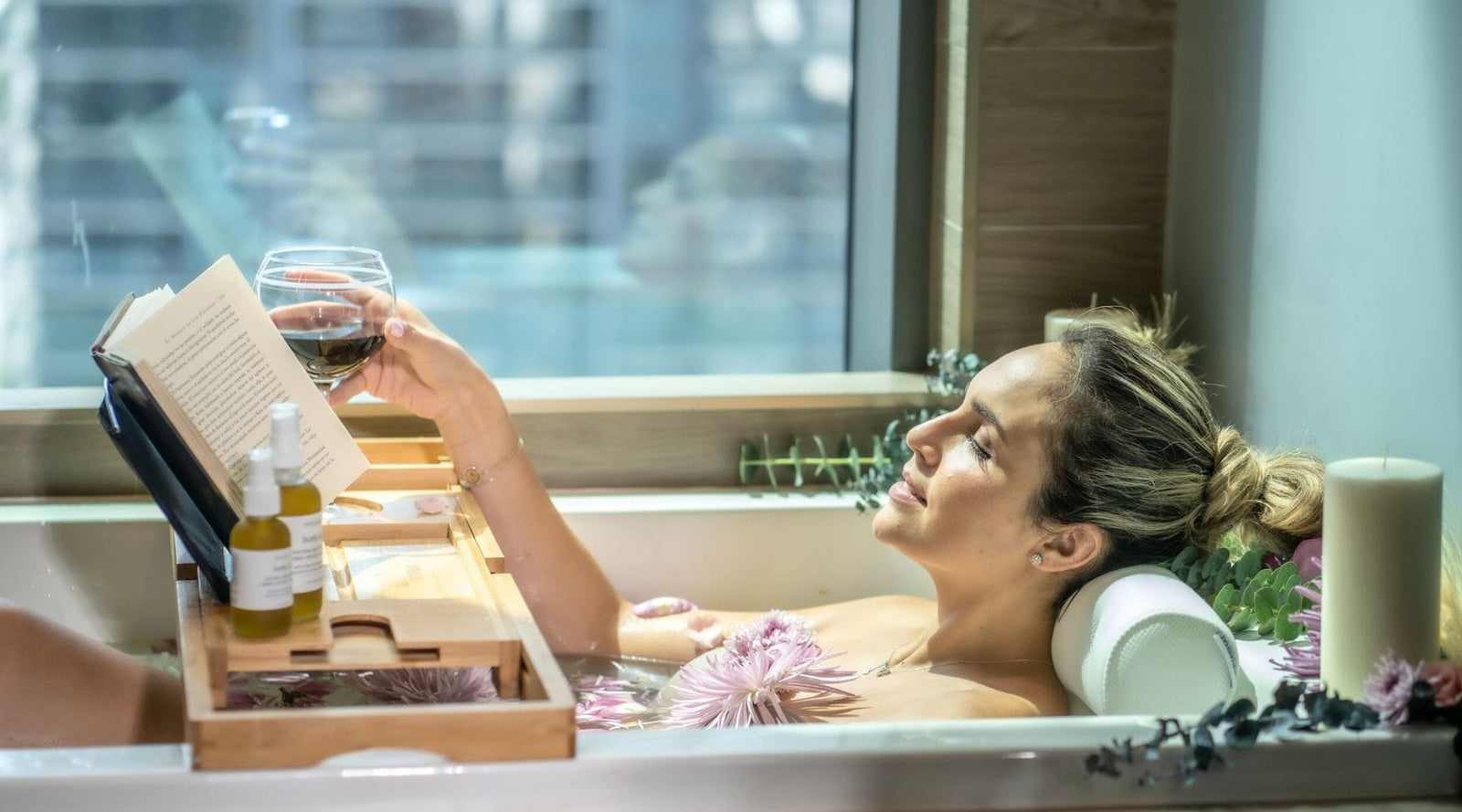 Woman indulging in a tranquil bath with Monsuri's premium bath tray and ultra-comfortable bathtub pillow