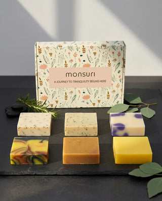 Monsuri Rise & Recover soap gift set — six full-size handmade bars and the botanical gift box on slate.