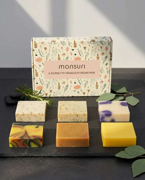 Monsuri Rise & Recover soap gift set — six full-size handmade bars and the botanical gift box on slate.