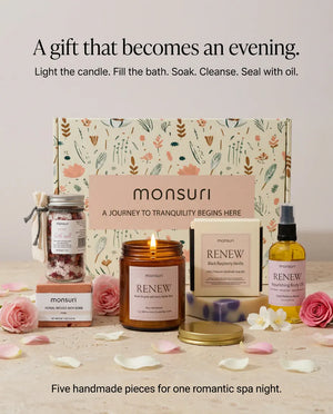 A gift that becomes an evening - light the candle, fill the bath, soak, cleanse, seal with oil. Five handmade pieces of the romantic spa gift set arranged in front of the botanical kraft gift box