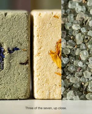 Three of the seven up close: the pressed texture of a bath bomb studded with dried cornflower, a second bath bomb with marigold petals, and the loose mineral crystals of a herbal bath salt.
