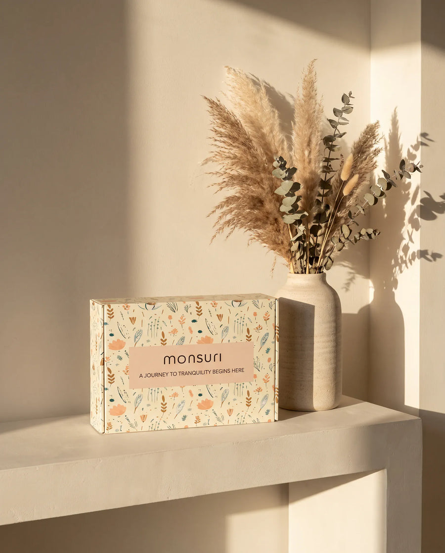The botanical kraft gift box as it ships — kraft shred, a eucalyptus sprig, the note inside.