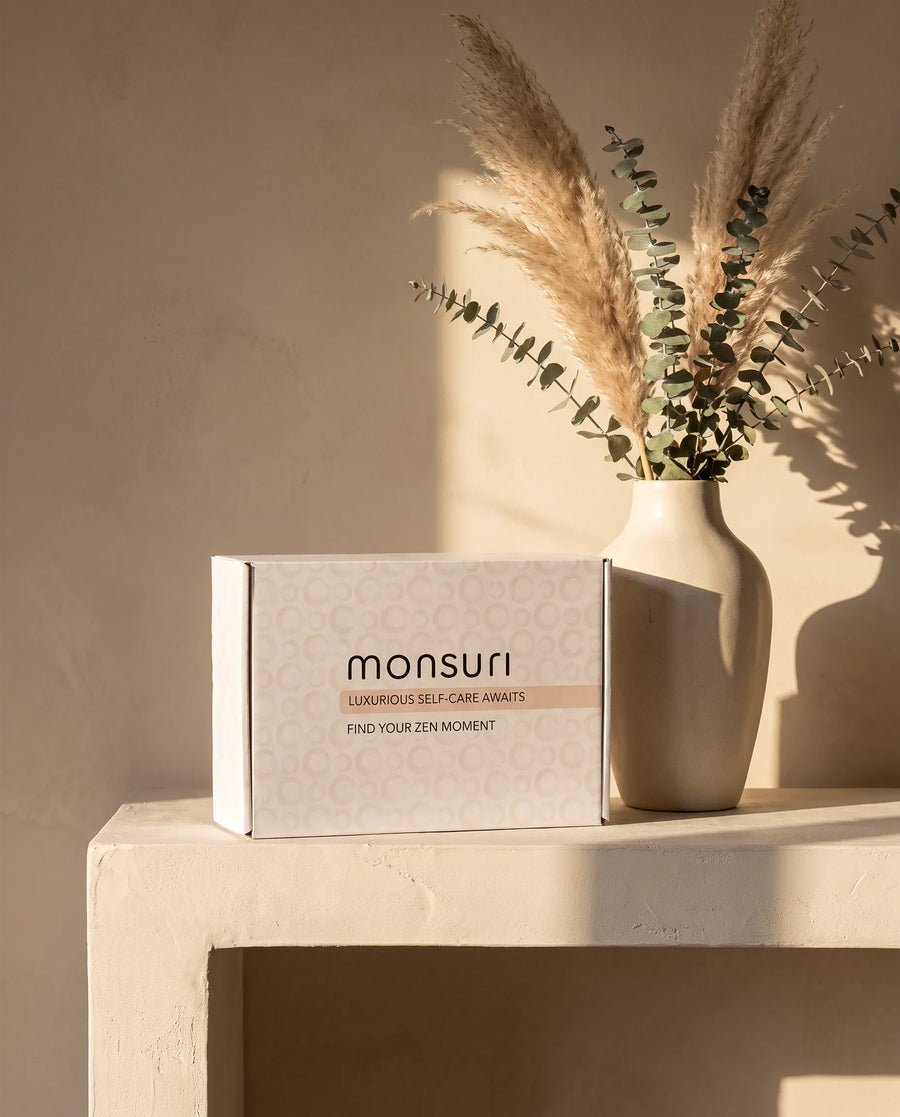 The botanical kraft gift box as it ships — kraft shred, a eucalyptus sprig, the note inside.