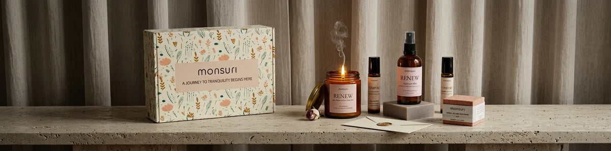 The five sympathy pieces along a travertine ledge with the botanical gift box, the candle lit and a card in its envelope, against a linen curtain