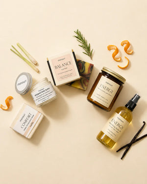 Overhead flat lay of the five pieces on cream with their ingredients scattered between them — lemongrass stalks, rosemary, curls of orange peel and vanilla pods.