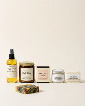 All five Bestie Boost pieces lined up on a cream backdrop — the ENERGY body oil, the ENERGY grapefruit candle, the boxed BALANCE Gobi Gold soap, the whipped body butter and the COMFORT vanilla bath bomb, with the marbled soap bar unwrapped in front.