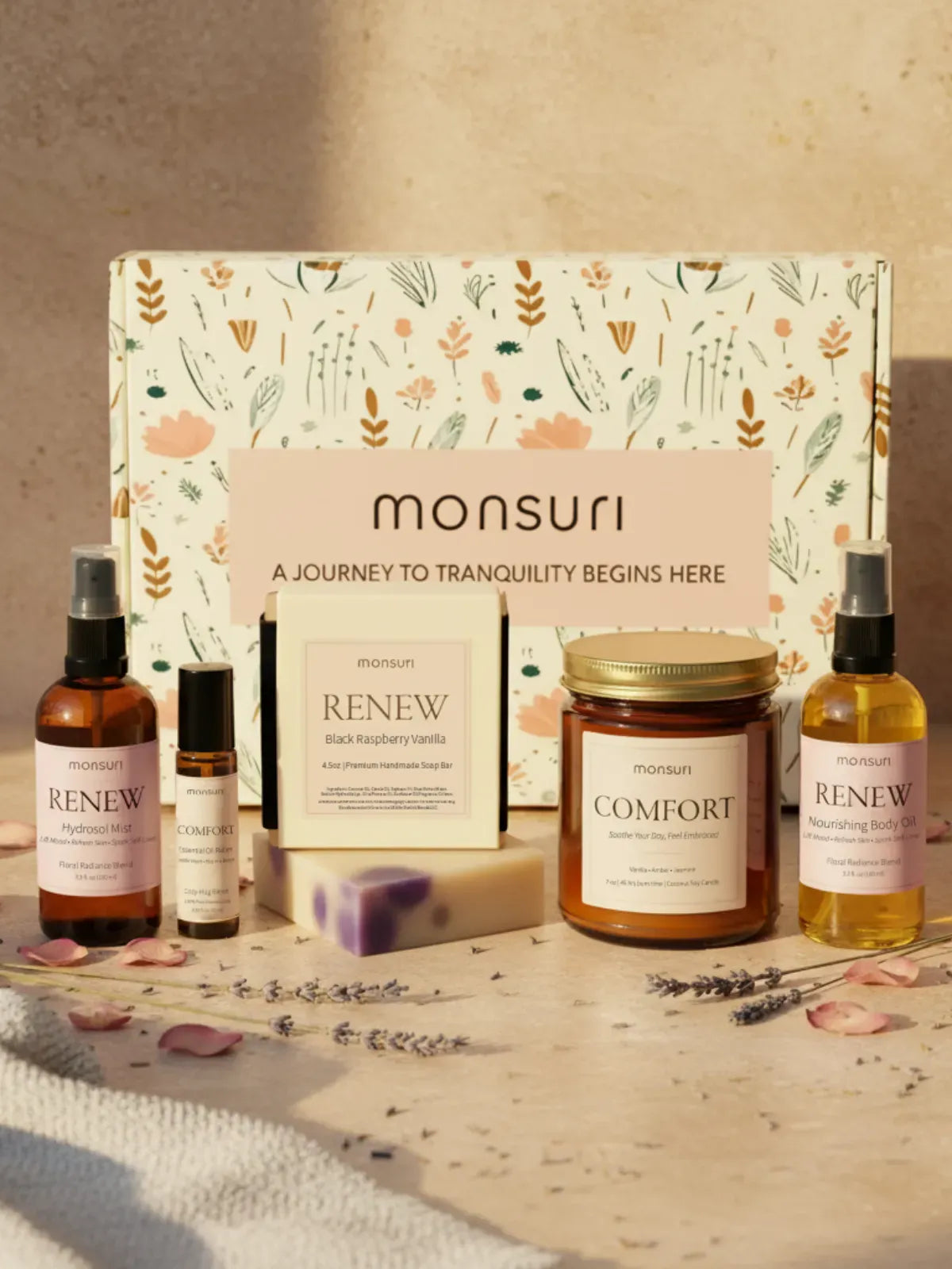 Thinking of you gift set with vanilla amber candle, raspberry vanilla soap, botanical body oil, hydrosol mist and essential oil roller arranged on marble surface