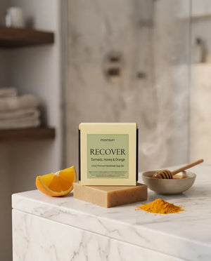 Turmeric Honey & Orange soap box and bar on marble by a steamy shower — natural golden soap bar