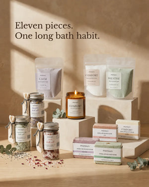 Eleven pieces, one long bath habit - the candle, bath soaks, bath salts and bath bombs styled together in warm afternoon light