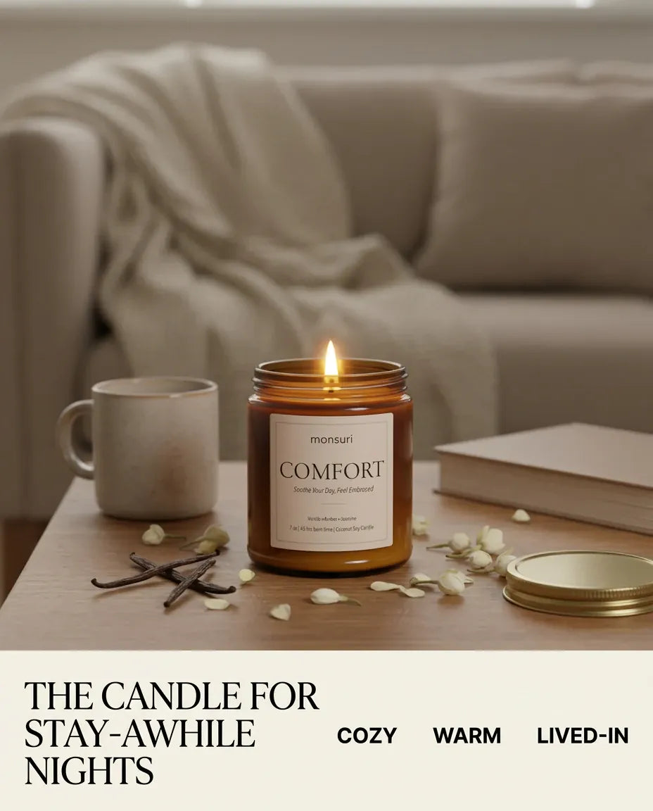 Infographic reading 'The Candle for Stay-Awhile Nights' with a lit Monsuri COMFORT candle on a coffee table beside a mug and book, tagged cozy, warm, lived-in.