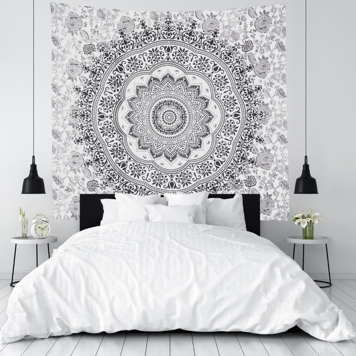 Black mandala tapestry hung as a wall hanging in a bedroom